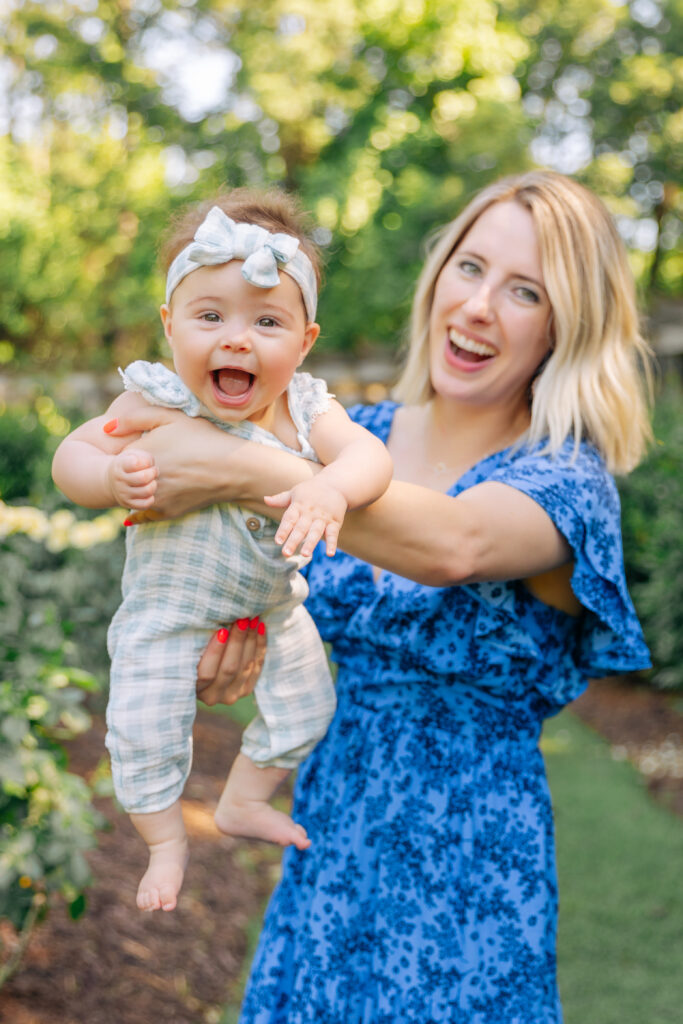 mom swings smiling baby girl around for motherhood family photo session with asheville photographer Rachel Marie Photography