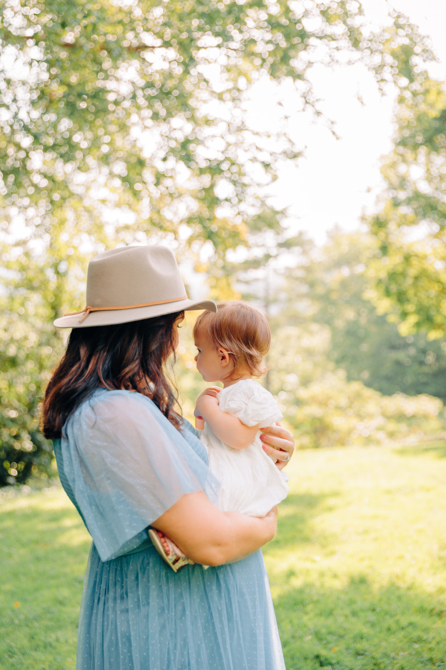 maternity photo session with pregnant mom and toddler girl in a glowy green field, taken by motherhood photographer Rachel Marie Photography in Asheville, NC