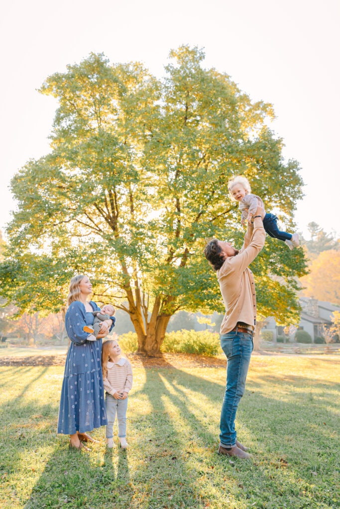 family photo session with two toddlers and a baby boy in front of a big beautiful tree in Hendersonville, NC with Asheville Family Photographer, Rachel Marie Photography