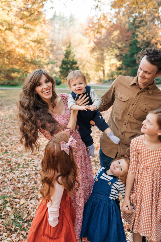 large family with four kids smiles and laughs during family photos with Rachel Marie Photography and the Botanical Gardens at UNCA with Rachel Marie Photography