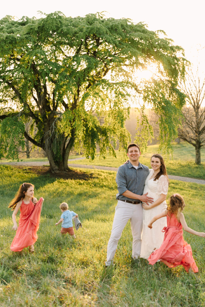 asheville family photographer captures expecting mama and family with toddlers and girls playing at the biltmore estate at sunset in the spring and summer