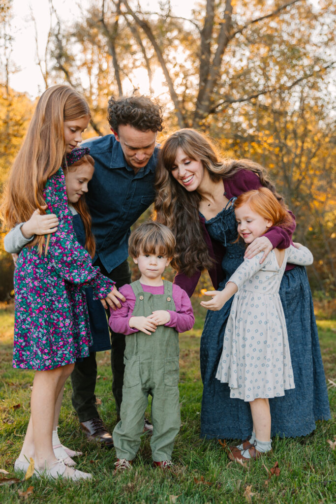 Family of six hugging and smiling during fun Fall Family Photo Session with Asheville, Photographer Rachel Marie Photography