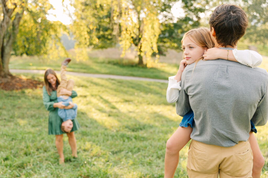 parents holding their children and having fun exploring during a family photo session at the Biltmore Estate in Asheville, NC