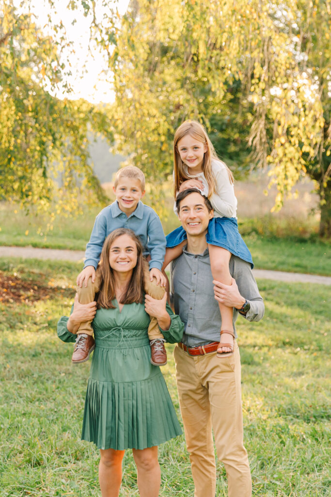 parents holding kids up on their shoulders during family photo session at the Biltmore Estate in Asheville, NC