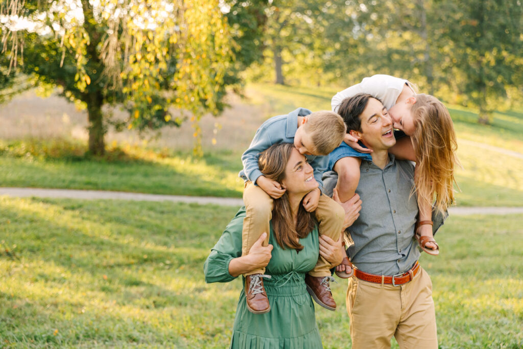 kids riding on their parents shoulders during a family photo session at the Biltmore Estate in Asheville, NC