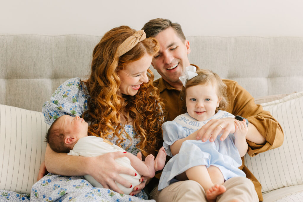 family snuggles on bed with toddler daughter and newborn son during in-home newborn session with Asheville Newborn Photographer Rachel Marie Photography