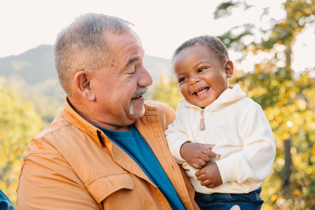 grandfather and grandson share a silly laugh during extended family photo session in Asheville, NC
