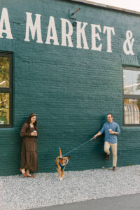 a cute couple and their dog sip coffee and stand outside of Ecusta Market and Cafe