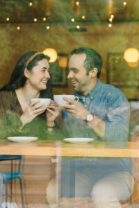 Asheville Family Photographer captures couple on a date drinking coffee in large white mugs at the Ecusta Market and Cafe in hendersonville, NC