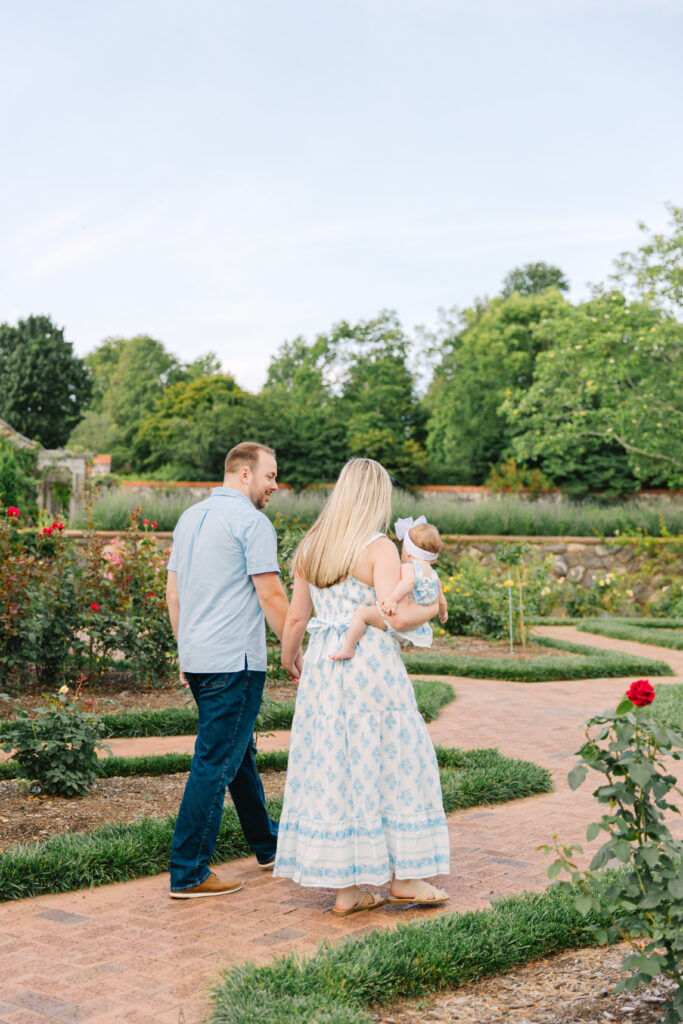 family walks down brick path through rose garden at the biltmore estate in asheville, nc during family photoshoot