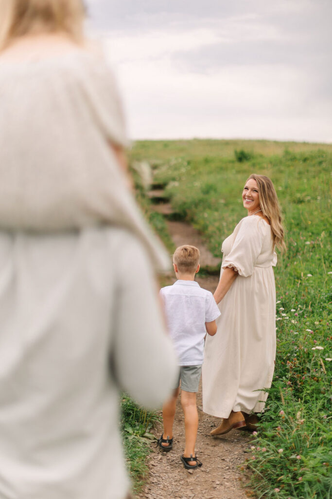 Family walks together up dirt path at family photo session at Max Patch, NC with Asheville Family Photographer Rachel Marie Photography
