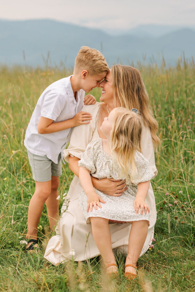 Mom snuggles with her son while holding her daughter on her lap during fun family adventure photo session with asheville family photographer Rachel Marie Photography