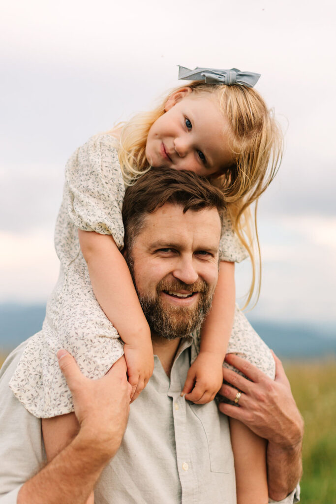 Daughter rests her head on her daddy's head while riding on his shoulders during fun family adventure photo session with asheville family photographer Rachel Marie Photography